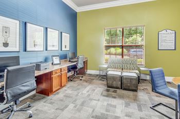 An office with a desk and chairs and a window